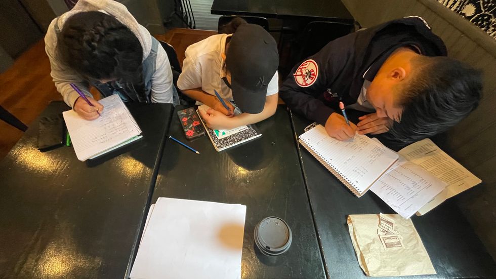 people writing in notebooks
