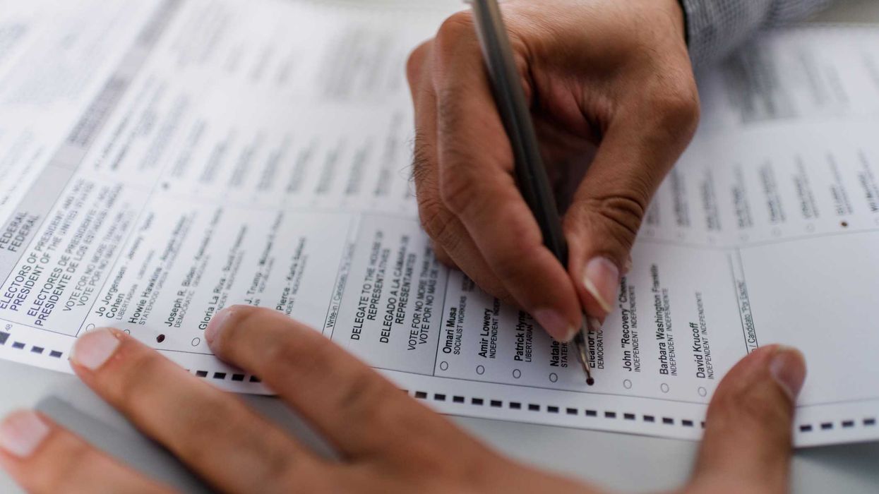Person filling out absentee ballot.