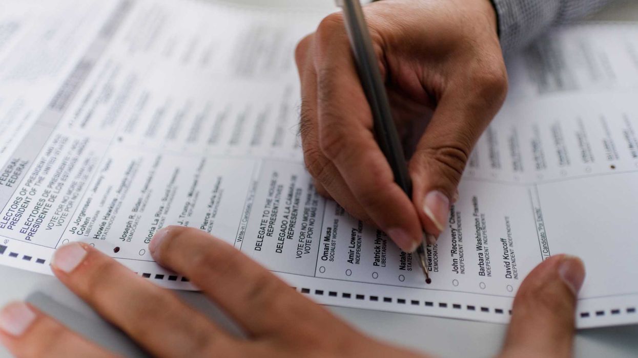 Person filling out absentee ballot.