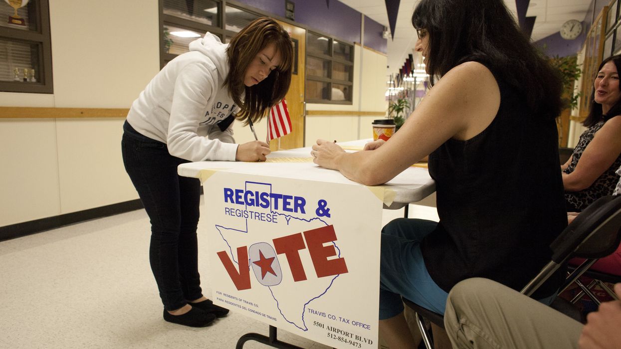 Person filling out paperwork at a voter registration table