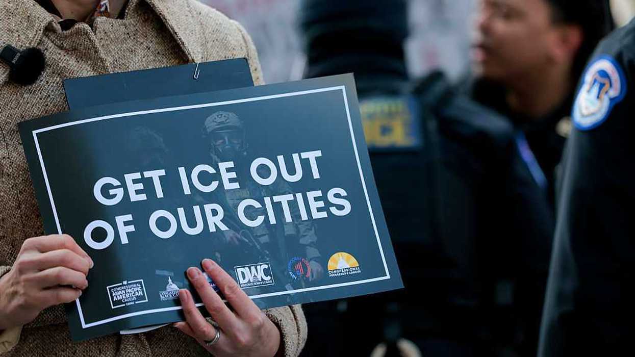 Person holding a sign that reads, "Get ICE out of our cities."
