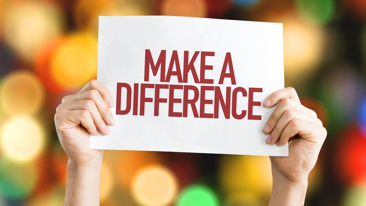 Person holding a sign that reads "Make a difference"