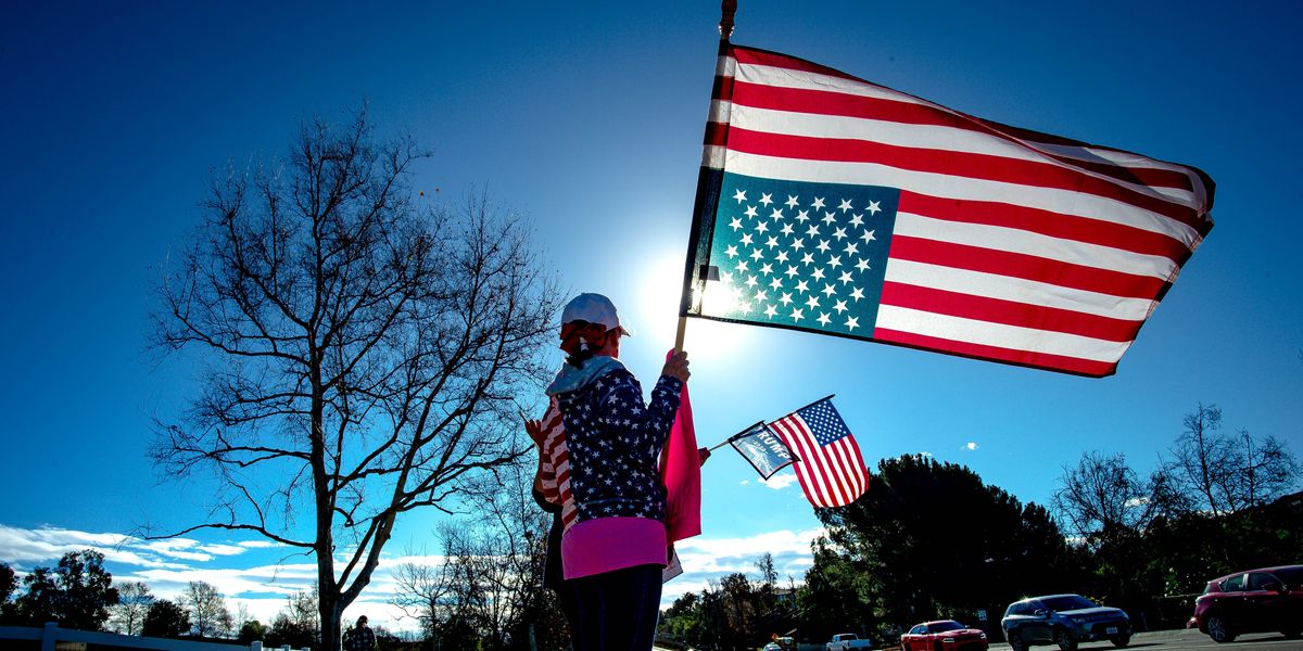 Person holding an upside down American flag