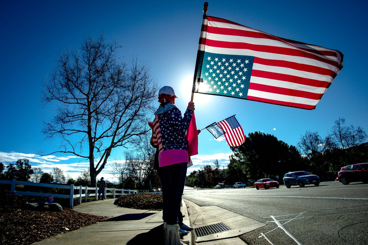 Person holding an upside down American flag