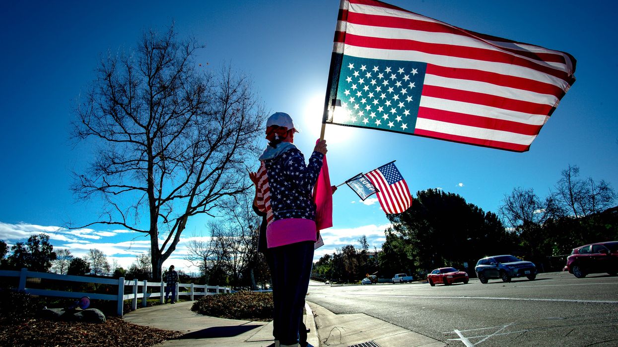 Person holding an upside down American flag