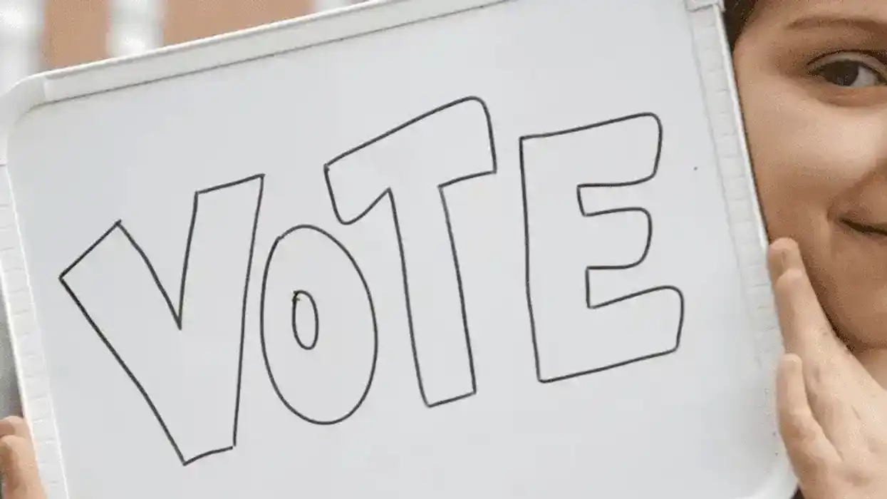 Person holding "Vote" sign.