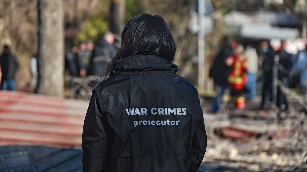 Person i jacket that reads "War Crimes prosecutor"