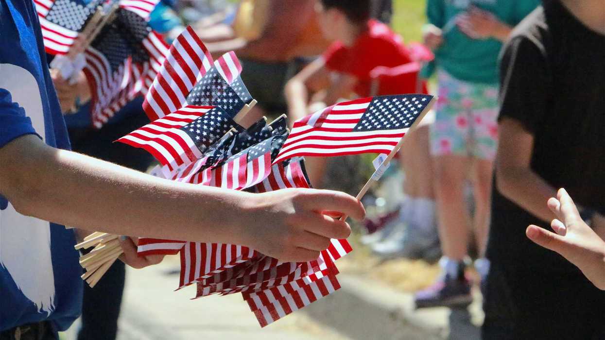 Person passing out small, hand-held American flags.