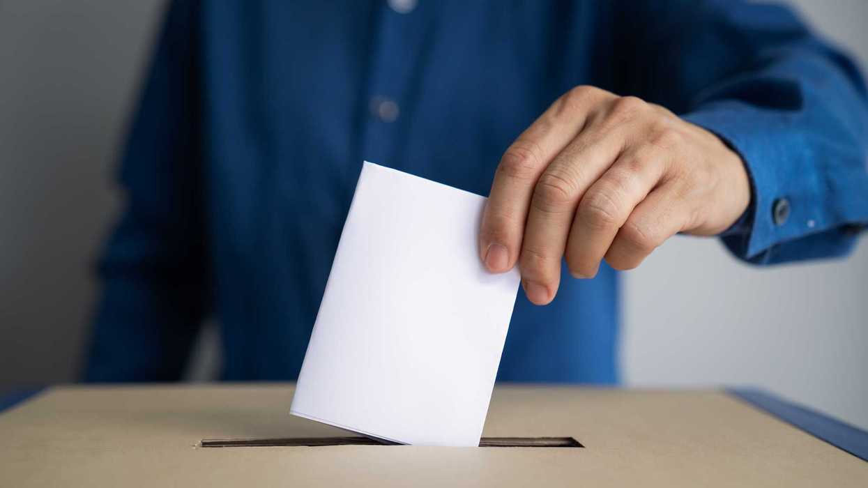 Person placing ballot in voting box