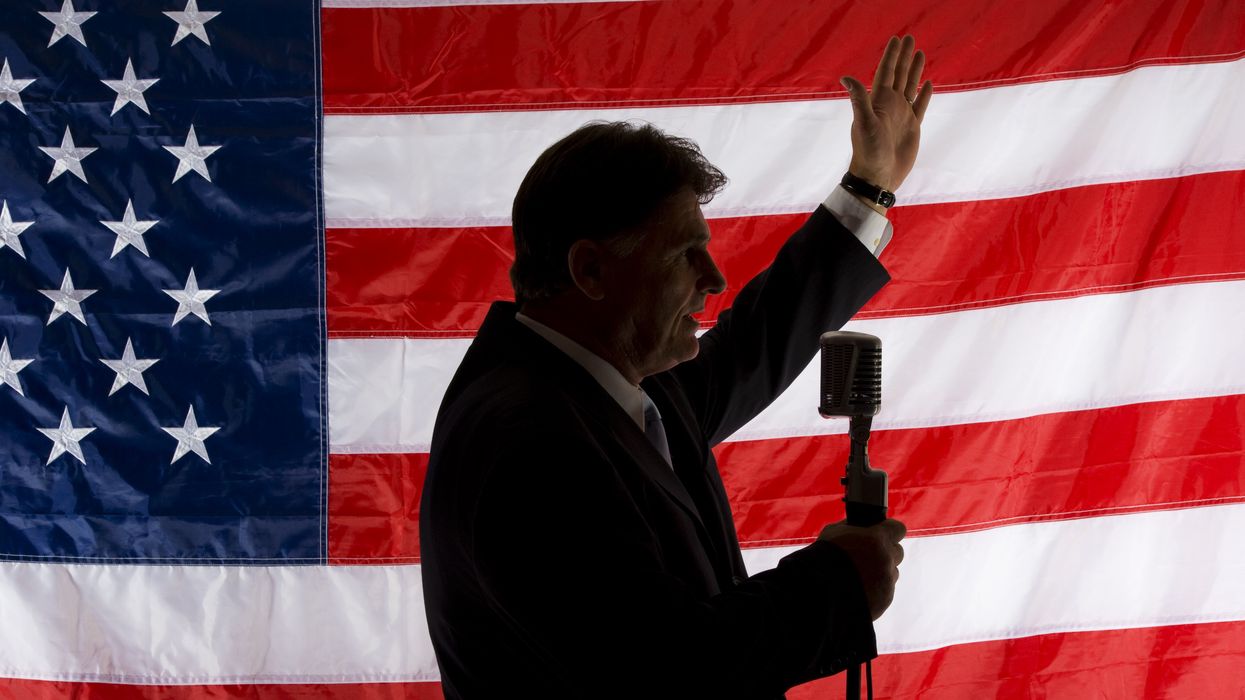 Person speaking in front of an American flag