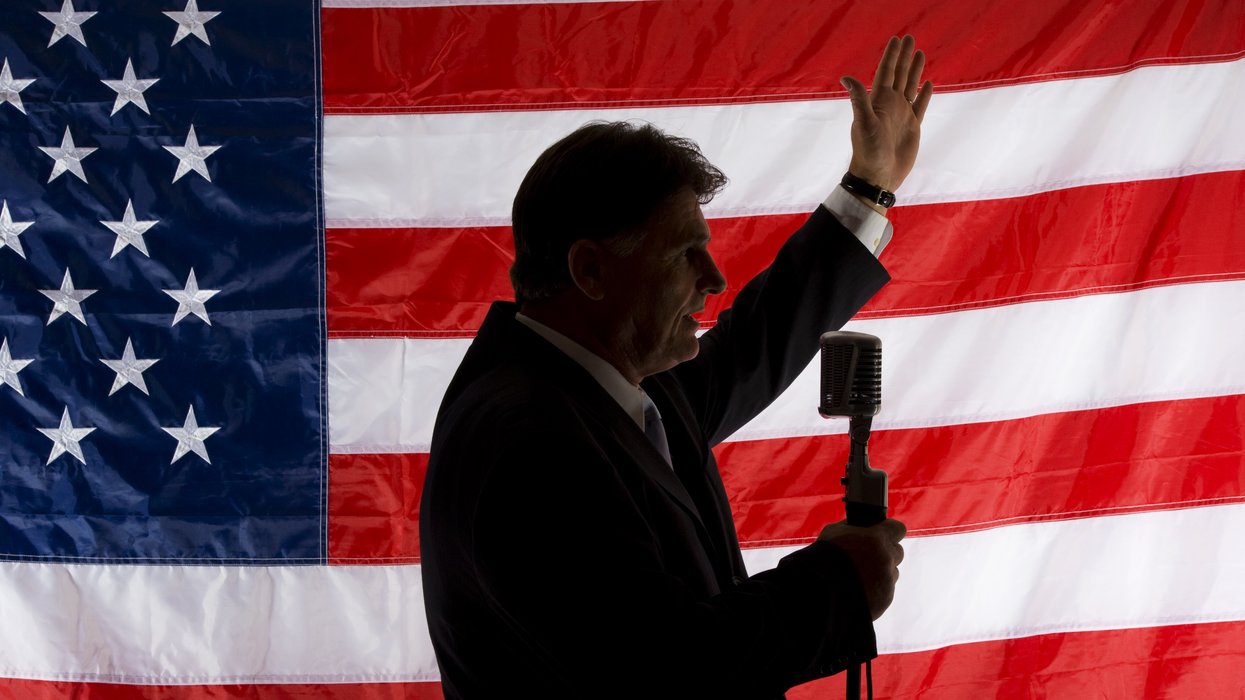 Person speaking in front of an American flag