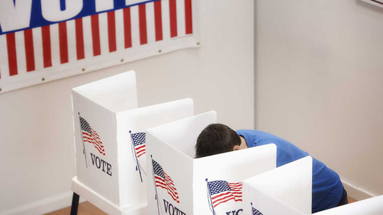 Person voting in a voting booth.