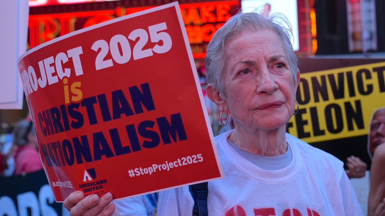 Perston holding a sign that reads "Project 2025 is Christian nationalism"