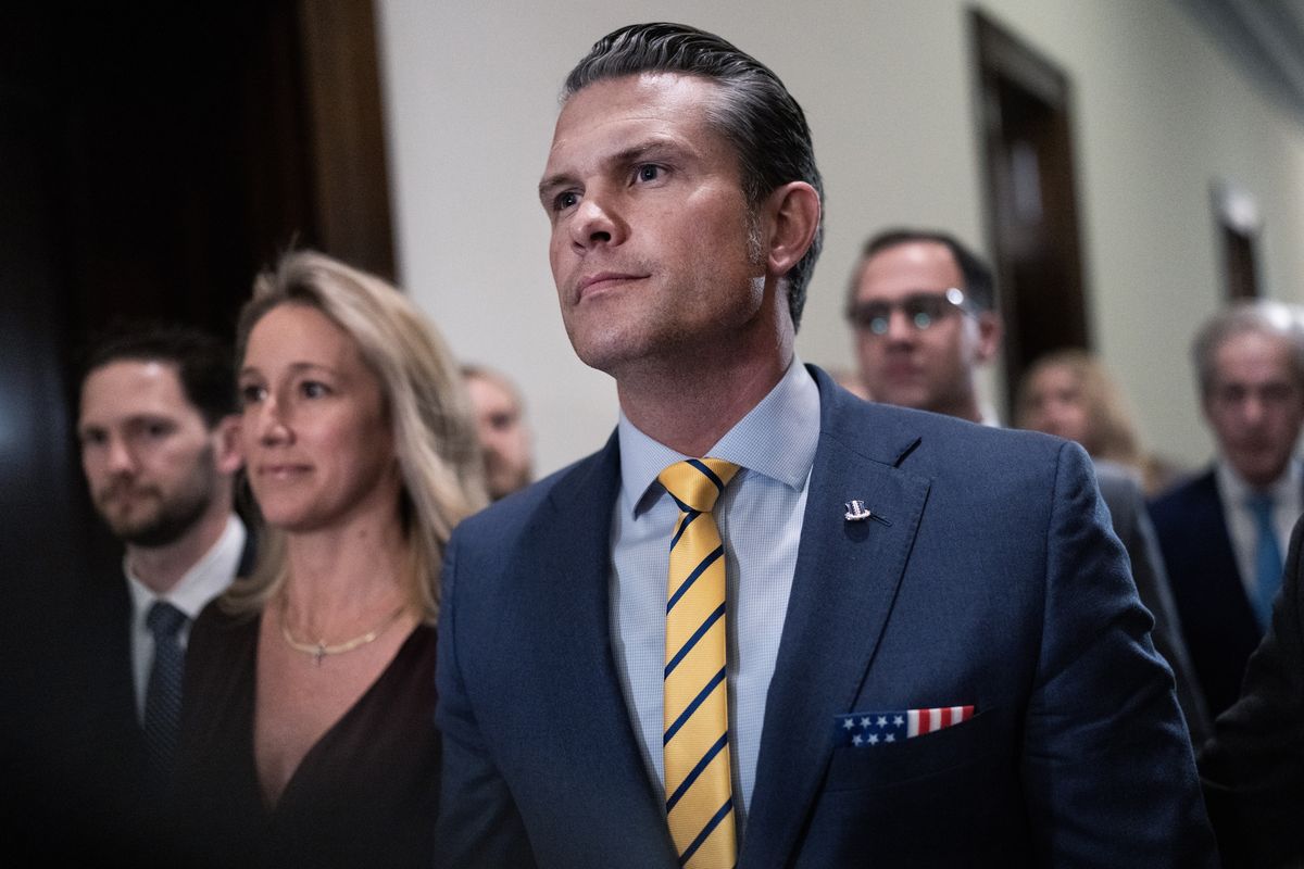 Pete Hegseth walking in a congressional hallway