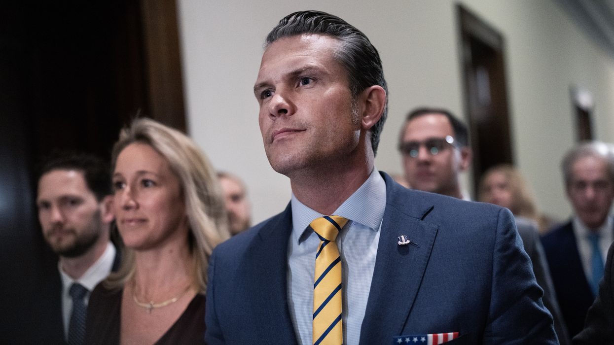 Pete Hegseth walking in a congressional hallway