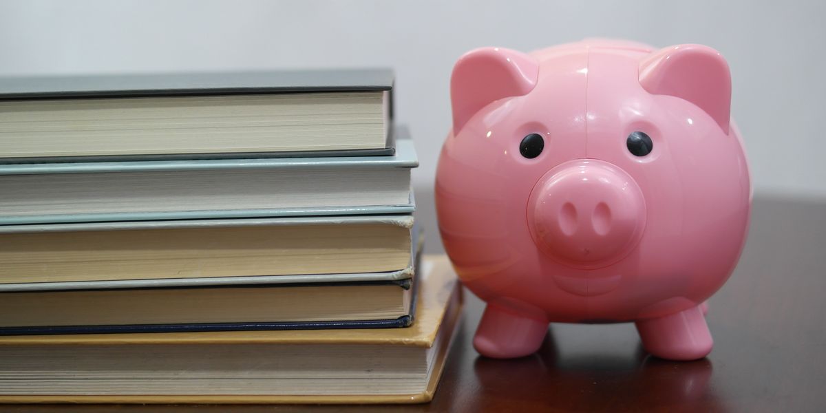 Piggy bank next to stack of textbooks