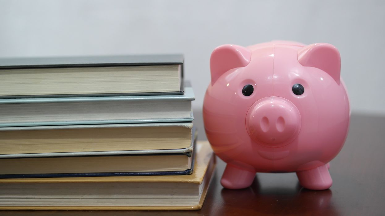 Piggy bank next to stack of textbooks