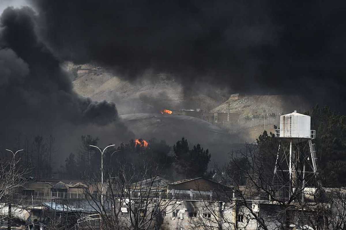 Plumes of smoke rise over the oil depot tanks hit by joint Israel-U.S.
