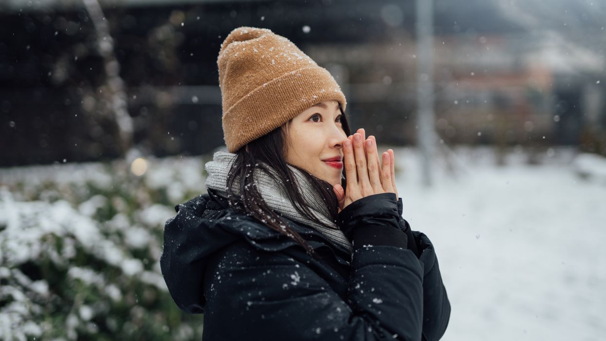 Portrait of young woman enjoying snow in the city.