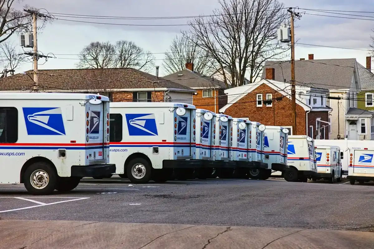 Post office trucks parked in a lot.