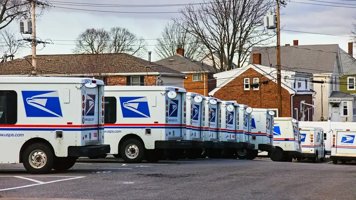 Post office trucks parked in a lot.