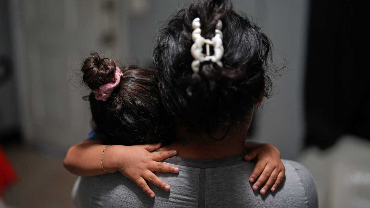 Pregnant asylum-seeker Yaoska, 32, comforts her two-year-old son