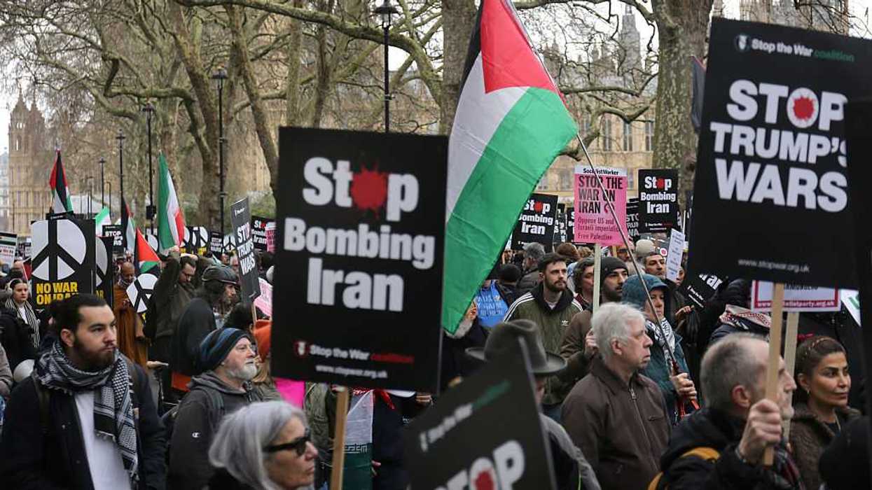 Protestors holding signs, many that say "Stop Bombing Iran."