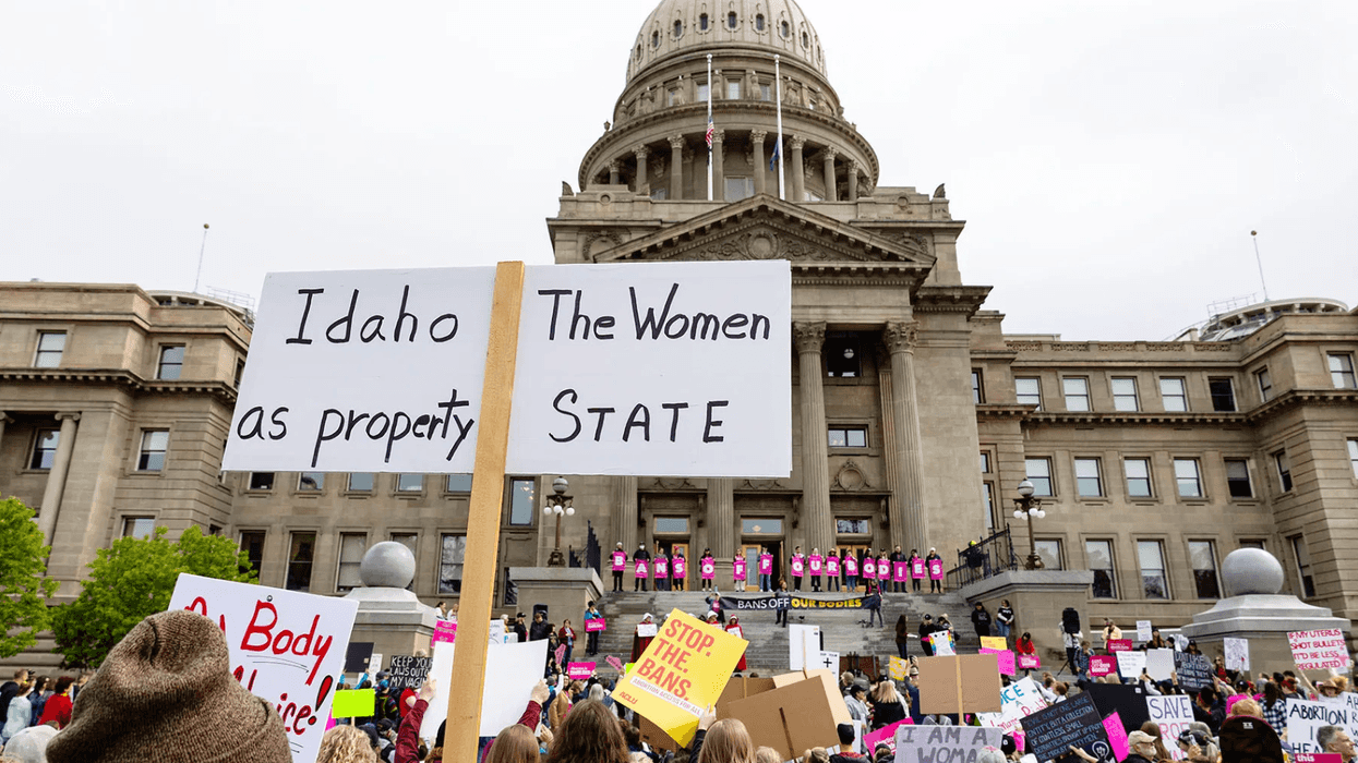 Protestors holding signs outside of the Idaho statehouse.