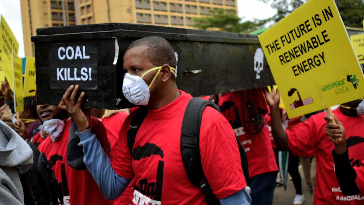 Protestors wearing masks and holding signs.