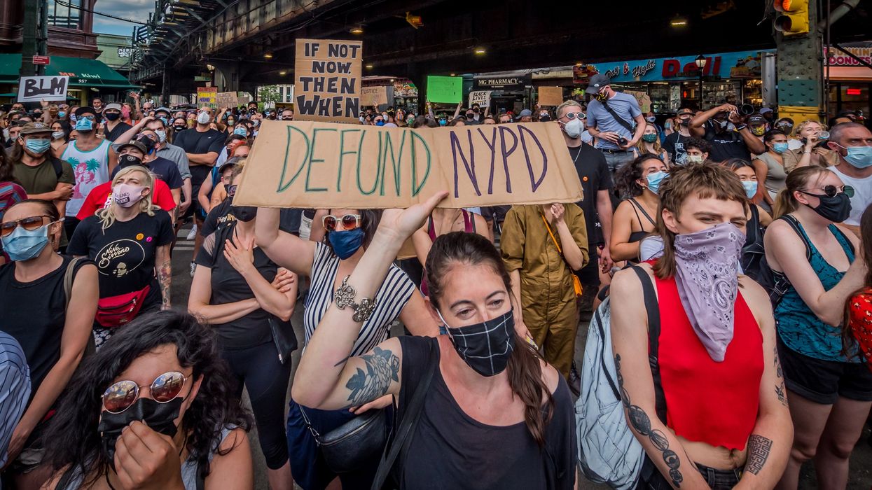 Protestors with sign called to "Defund NYPD"