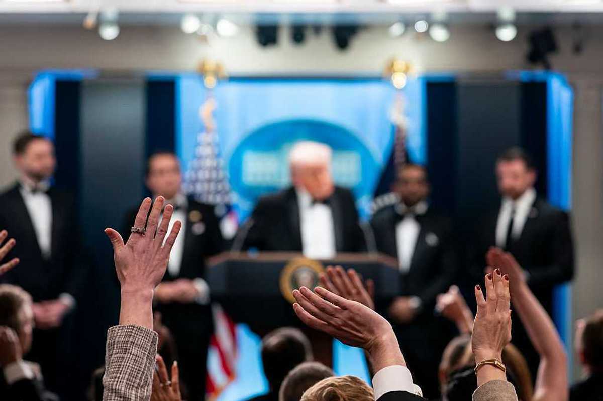 Reporters and members of the media raise their hand to ask a question to U.S. President Donald Trump.