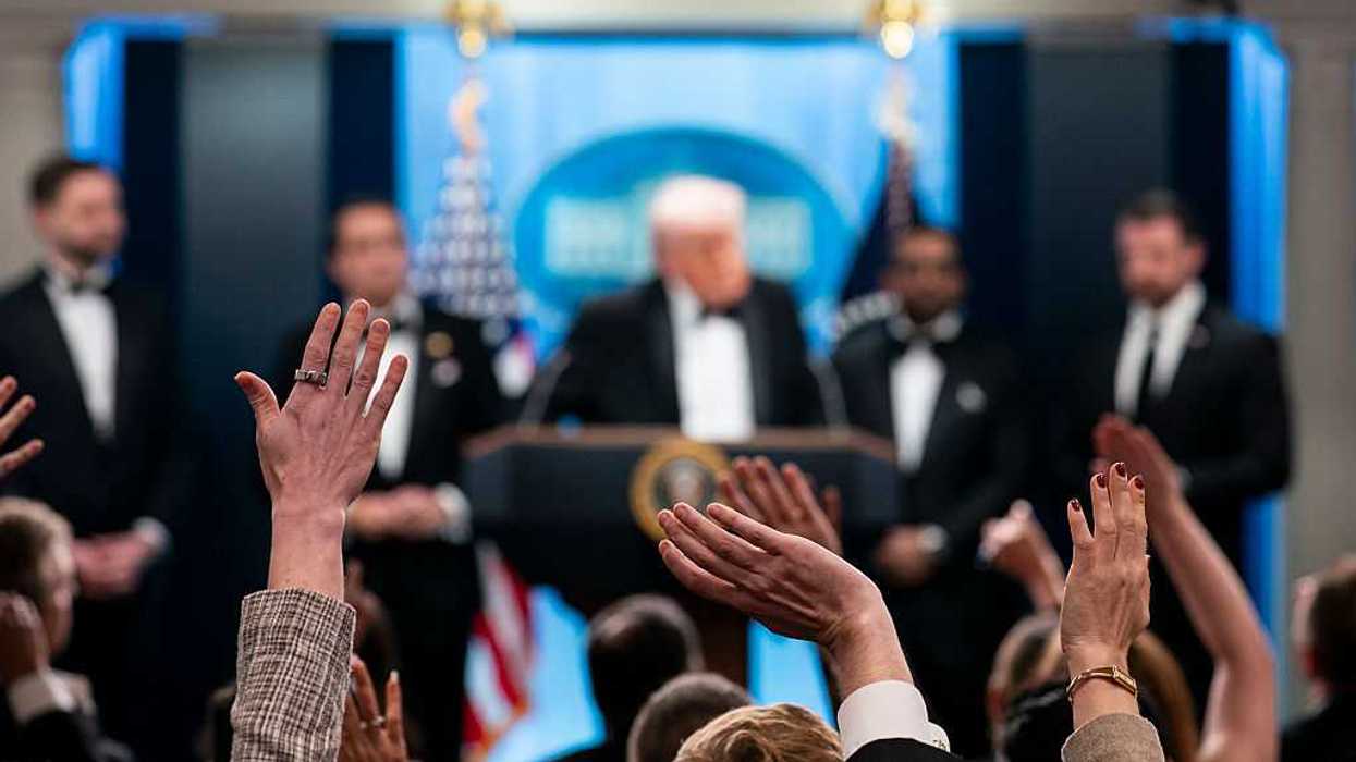 Reporters and members of the media raise their hand to ask a question to U.S. President Donald Trump.