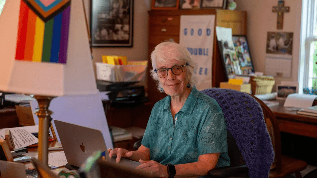 Rev. Carter Heyward sitting at her desk at home.