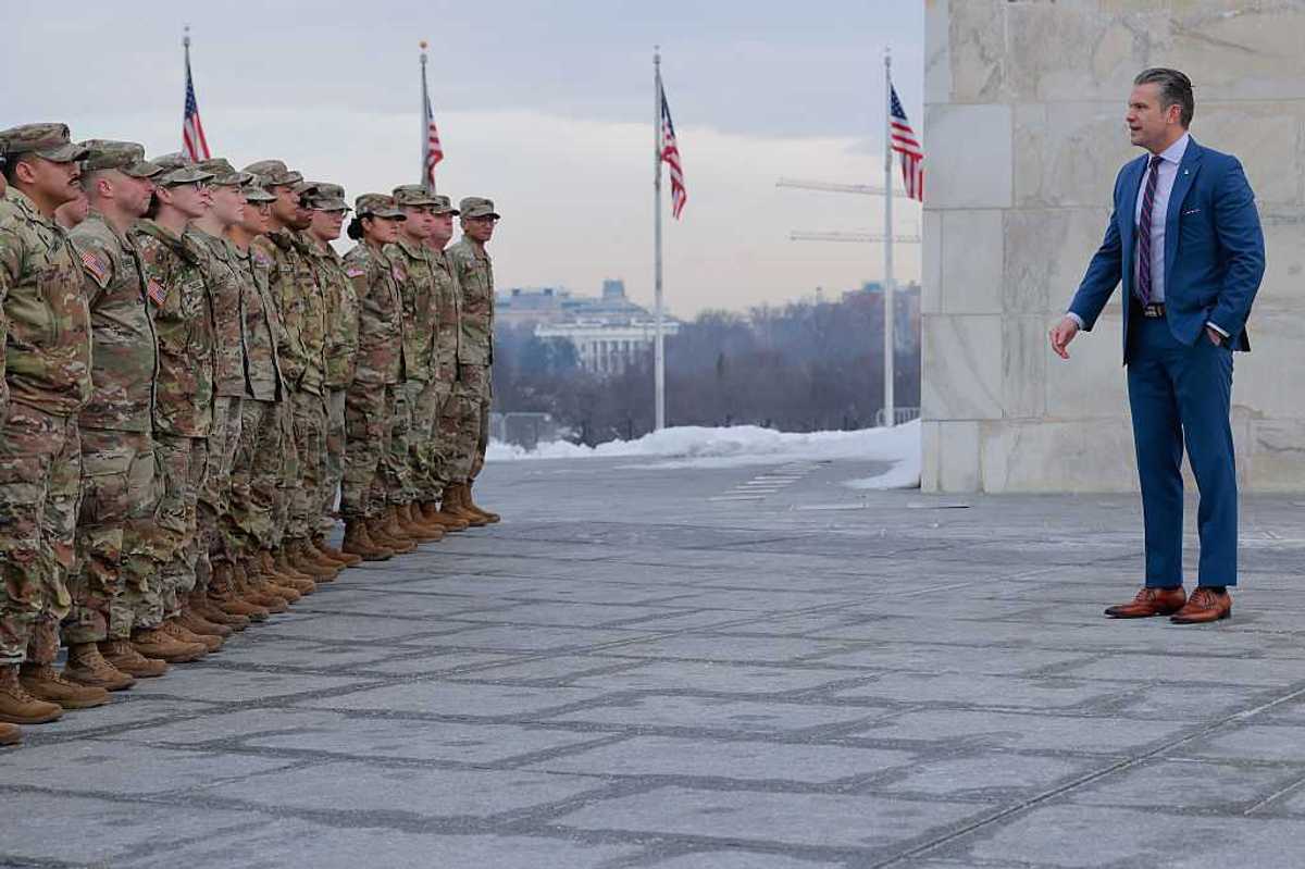 Secretary of War Pete Hegseth stands in front of a group of National Guard troops.