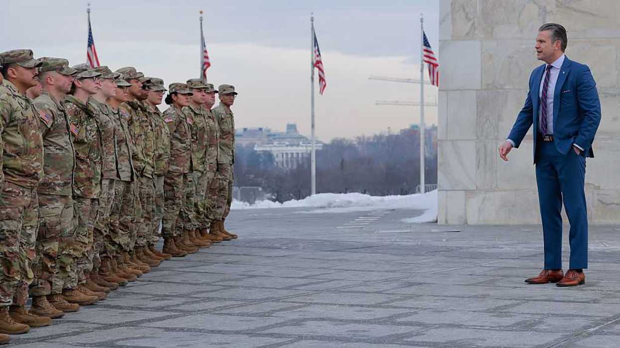 Secretary of War Pete Hegseth stands in front of a group of National Guard troops.