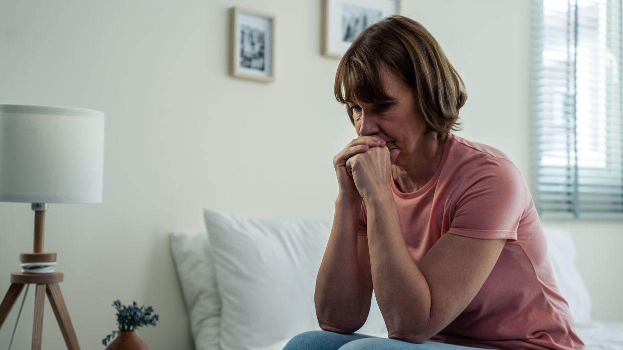 Senior older, depressed woman sitting alone in bedroom at home