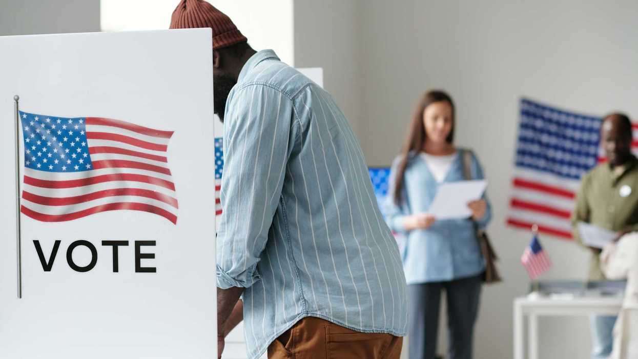 Side view of young African American male voter filling in ballot