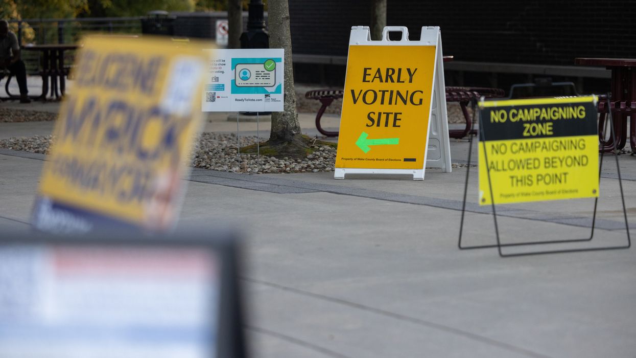 Signs in a walkway, including one that reads "Early Voting Site" with an arrow pointing the way