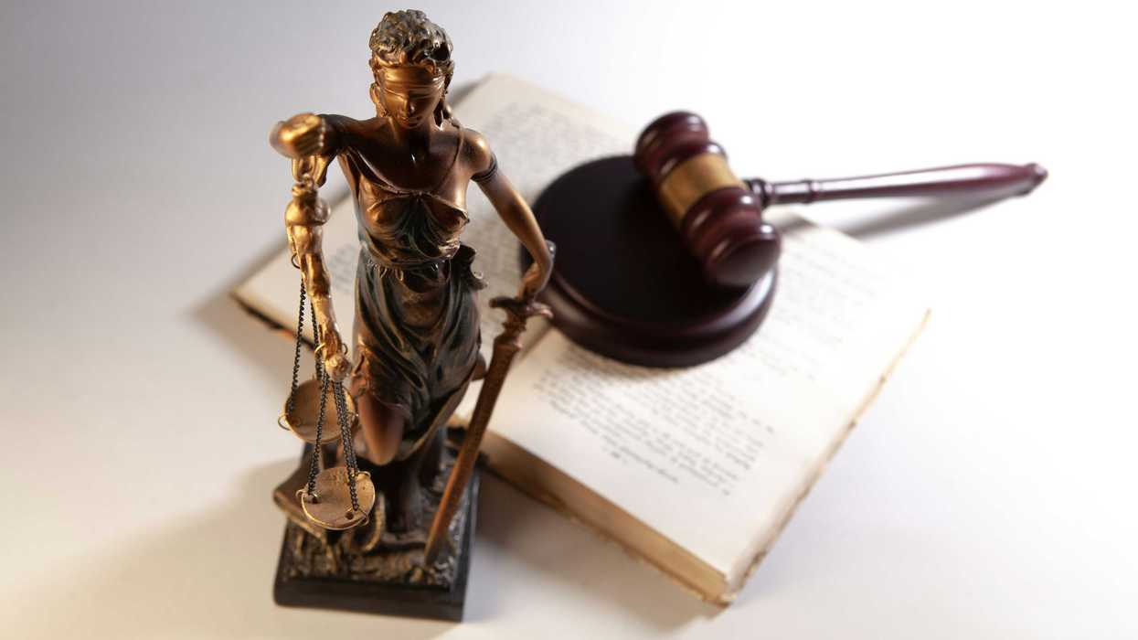 Statue of justice, gavel, and open book on table
