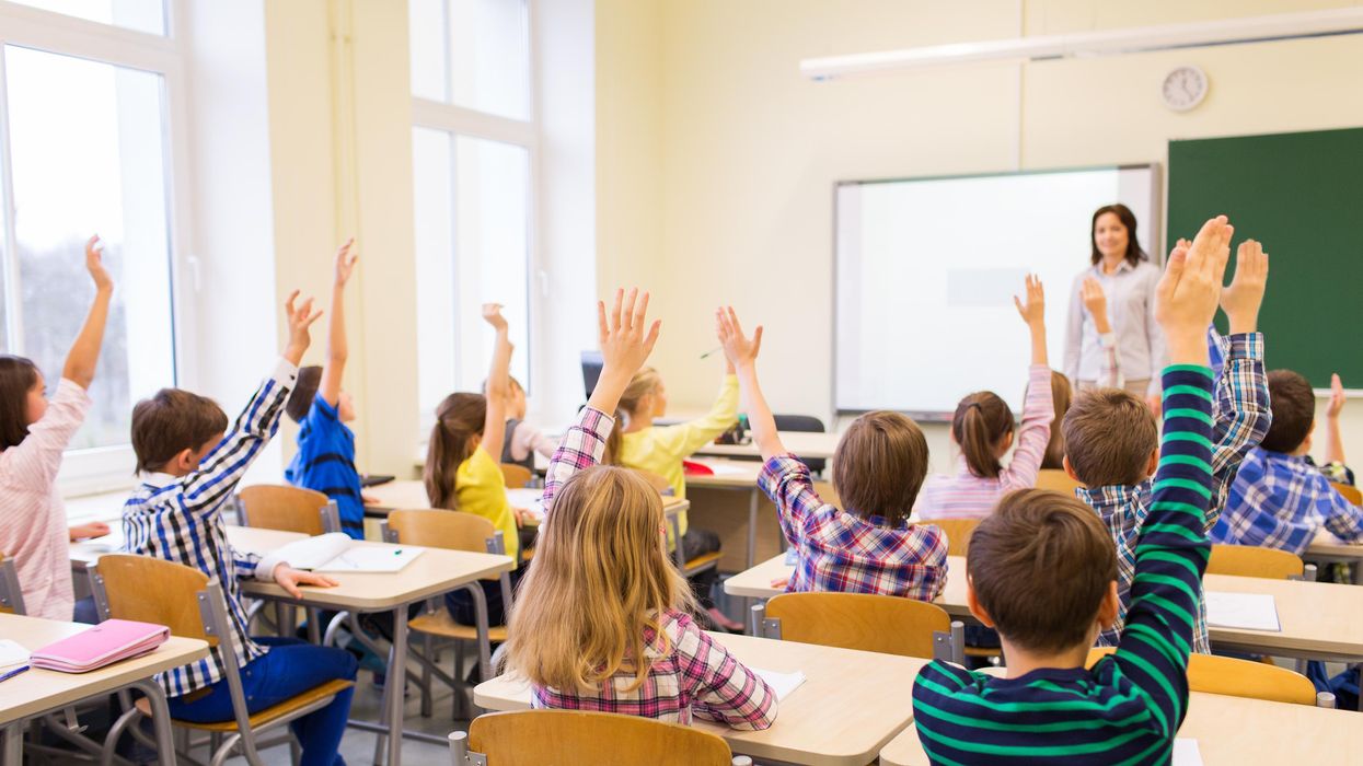 Students raising their hands in a classroom