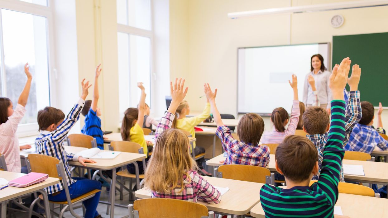 Students raising their hands in a classroom