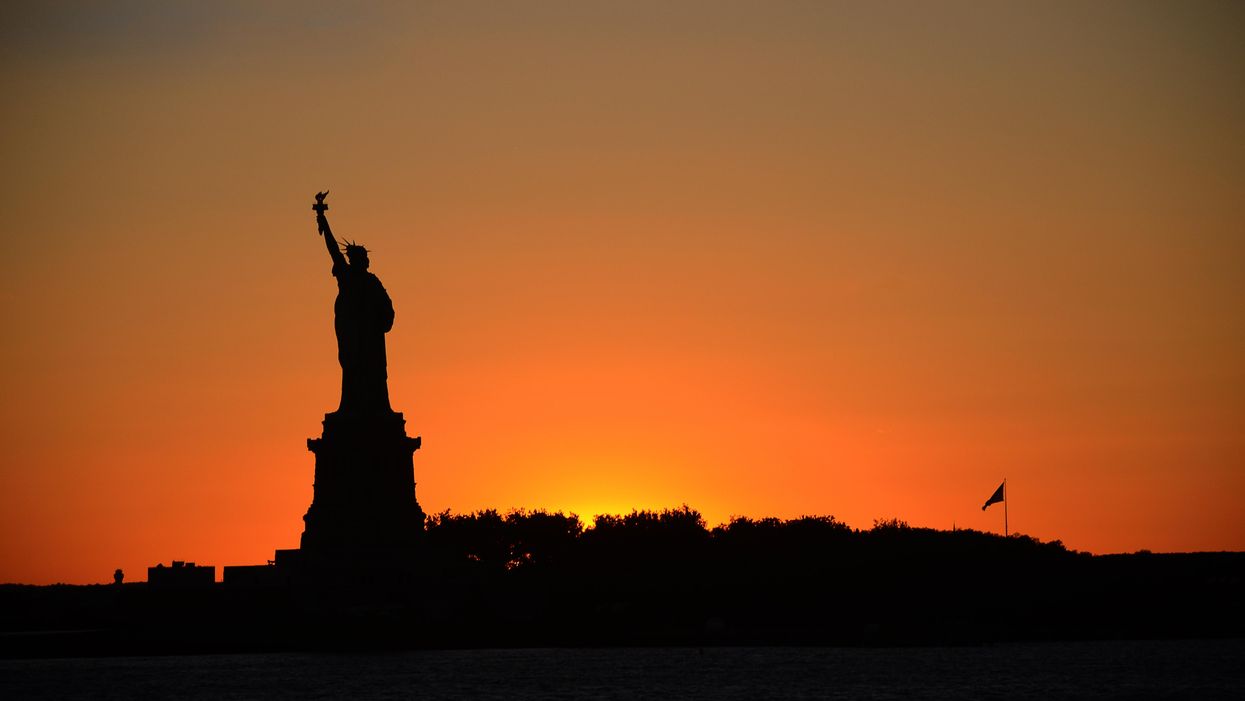 Sunrise behind the Statue of Liberty