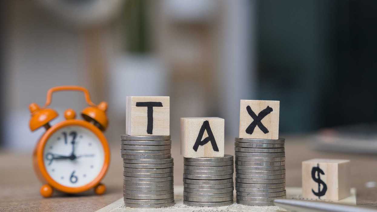 Tax Word on Wooden Block With Calculator and Tax Form