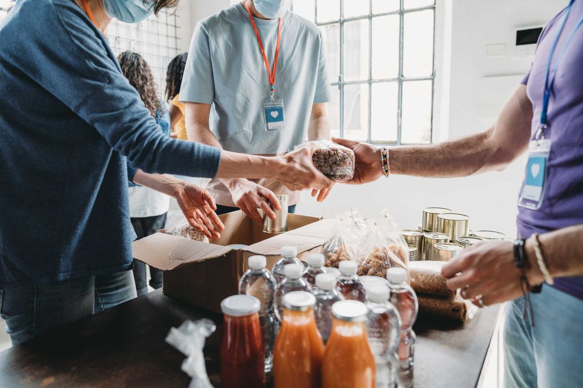 Three volunteers organizing food to donate.