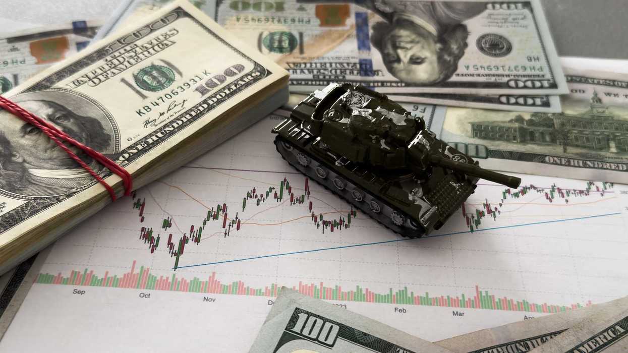Toy tank on the background of dollar bills