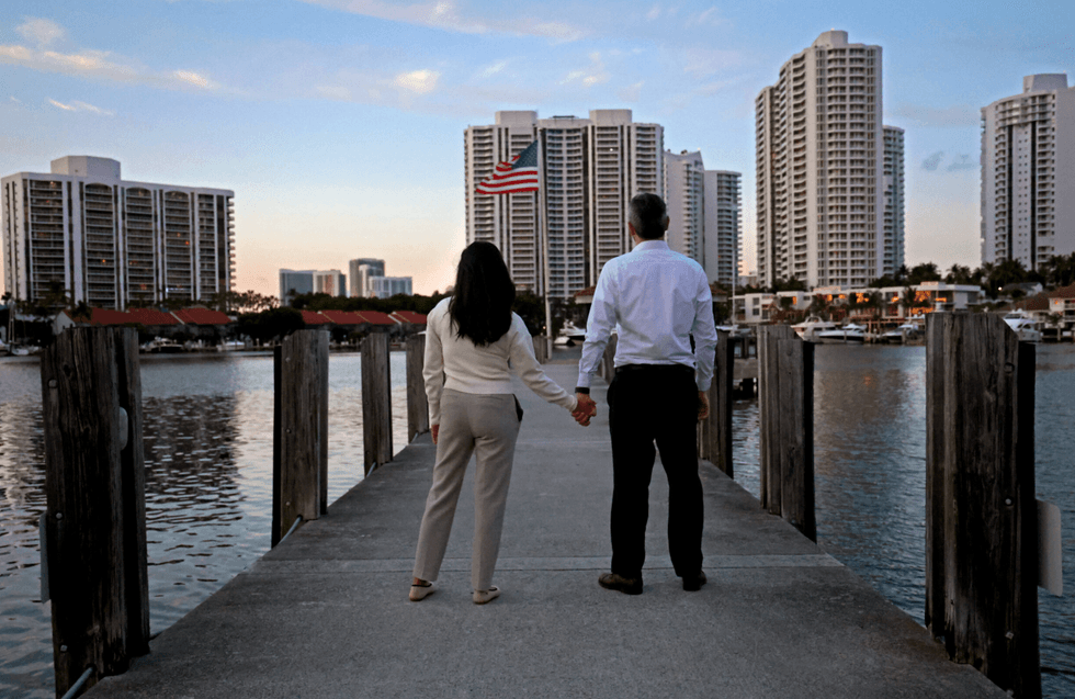 TPS recipients Mariana and Antonio pose for a photo on the dock of a marina in Aventura, Florida