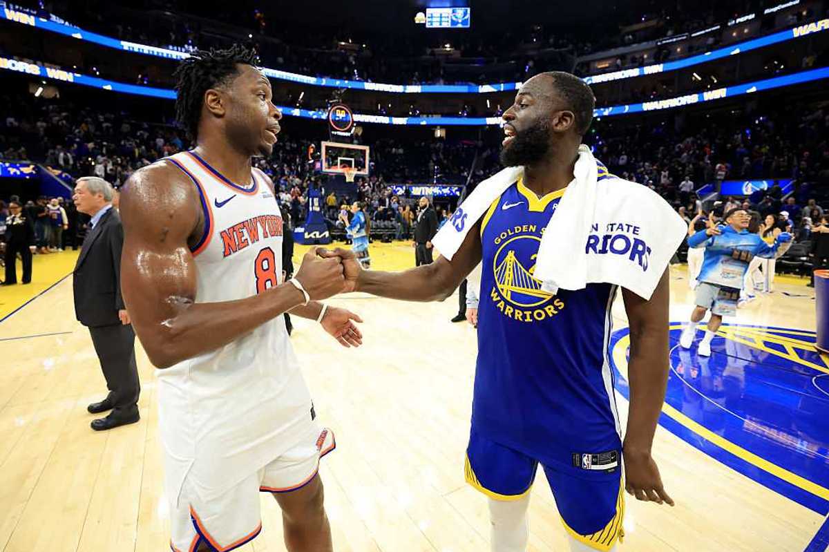Two basketball players shaking hands on the court.