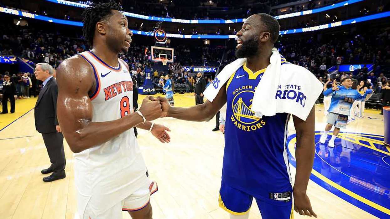 Two basketball players shaking hands on the court.