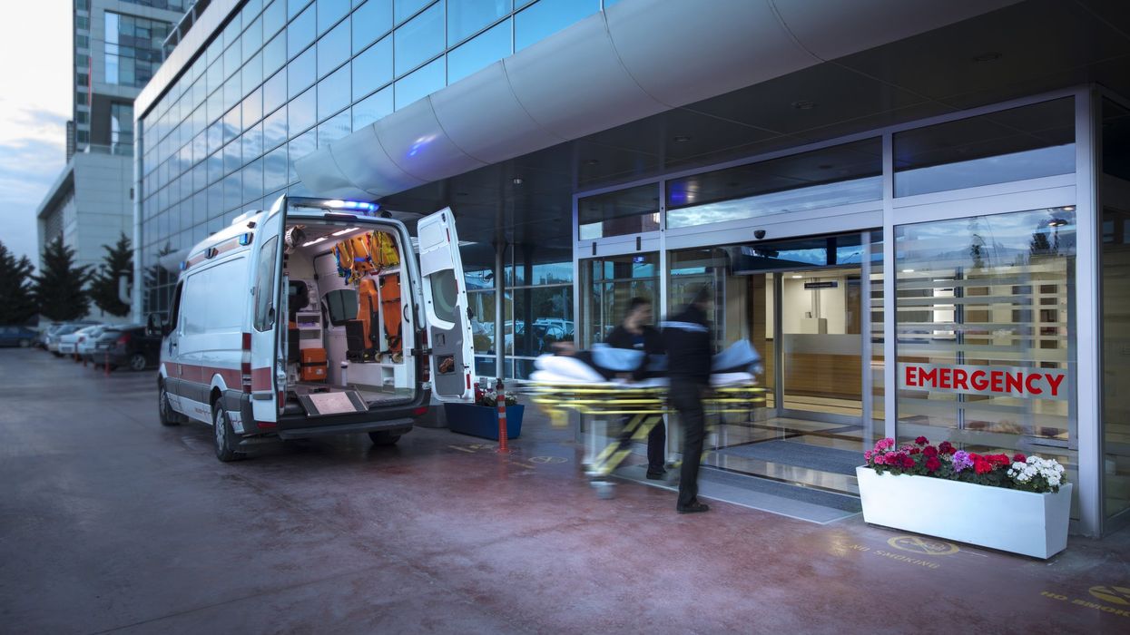 Two paramedics bringing in a person on a stretcher into a hospital.