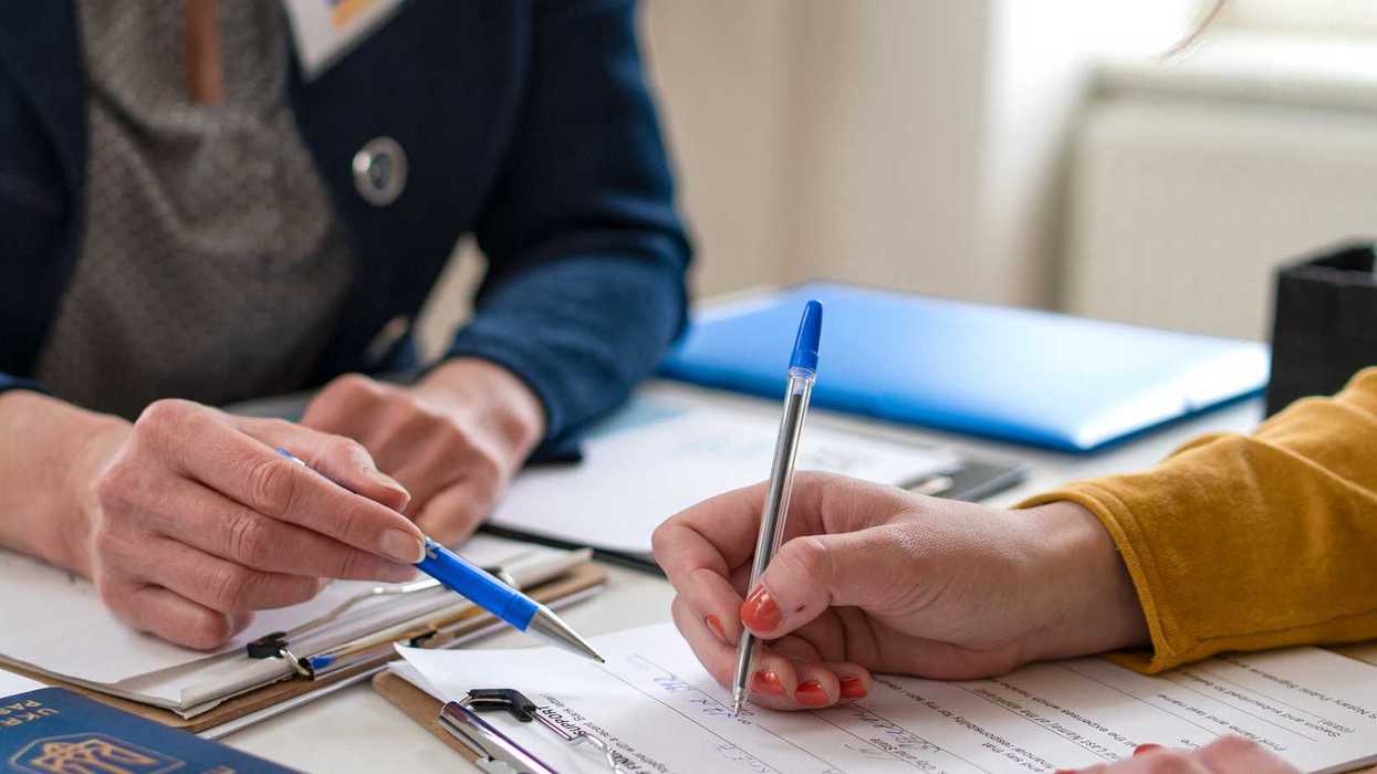 Two people signing papers.
